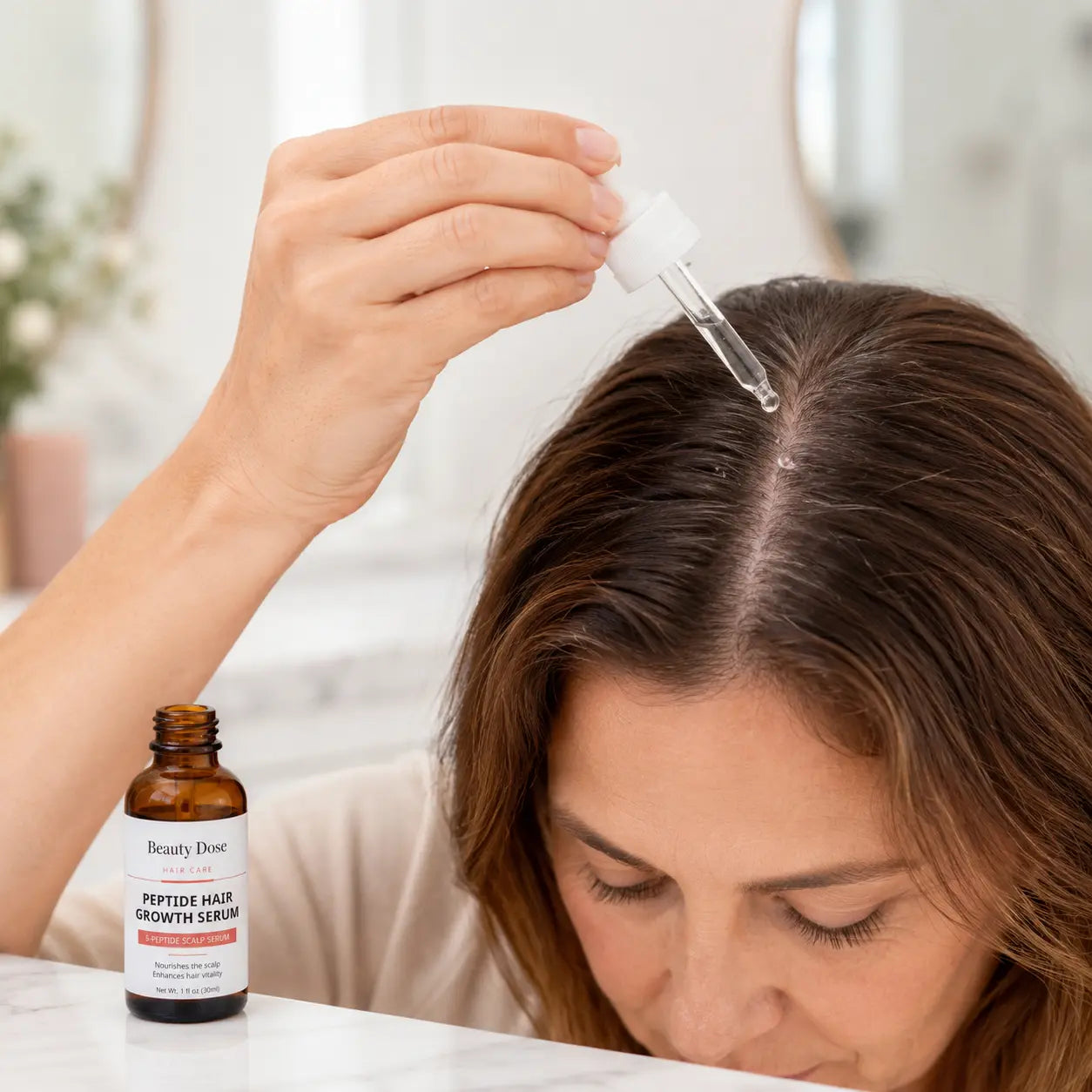 Applying a few drops of Beauty Dose Peptide Hair Serum directly to the scalp